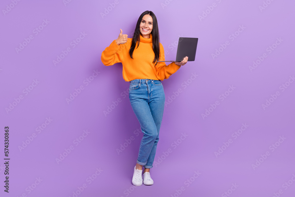 Full length photo of charming adorable lady wear trendy denim clothes use modern device thumb up isolated on purple color background Full length photo of charming adorable lady wear trendy denim clothes use modern device thumb up isolated on purple color background
