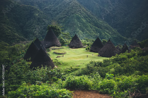 Traditional houses surrounded by mountains and vegetation photo