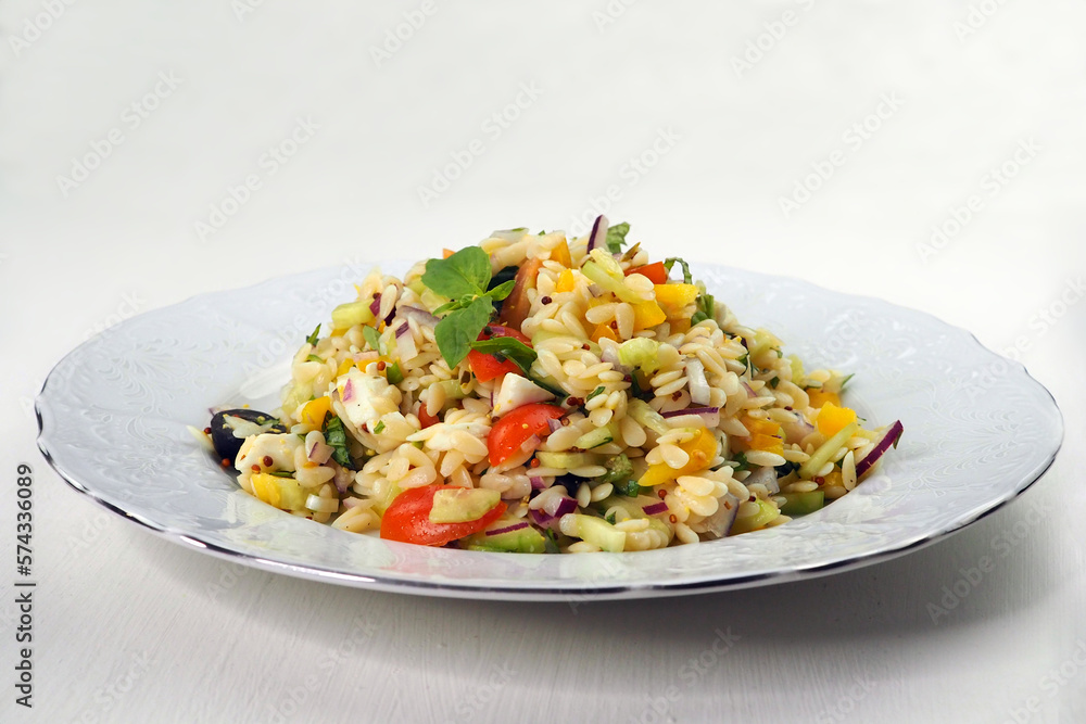 Mediterranean salad with orzo pasta on white plate Mediterranean salad with orzo pasta on white plate