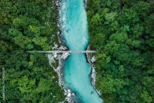 Suspension bridge over a blue river in the middle of the forest (Soca valley, Slovenia)