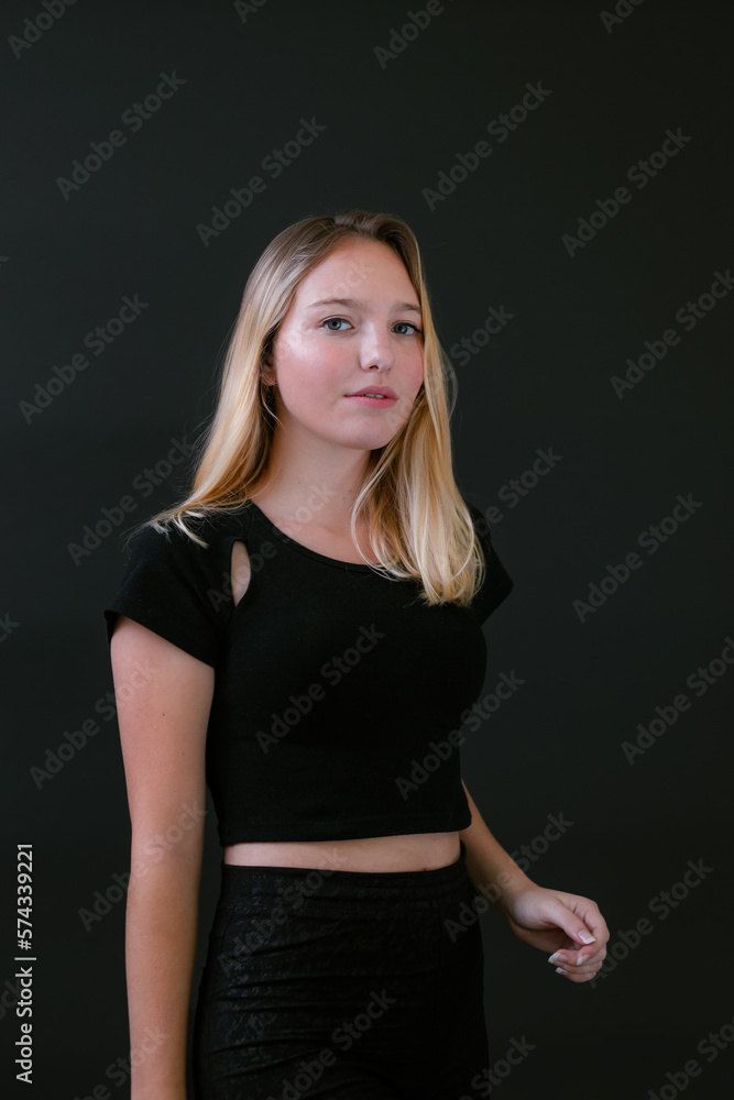 Beautiful young caucasian girl on dark background. Young blond hair female fashion model on black background. Fashion photoshoot. Beautiful young caucasian girl on dark background. Young blond hair female fashion model on black background. Fashion photoshoot.