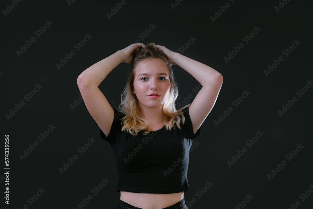 Beautiful young caucasian girl on dark background. Young blond hair female fashion model on black background. Fashion photoshoot. Beautiful young caucasian girl on dark background. Young blond hair female fashion model on black background. Fashion photoshoot.
