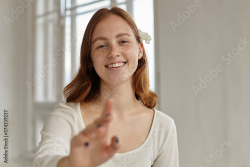 indoor portrait of young ginger female touching you and smile