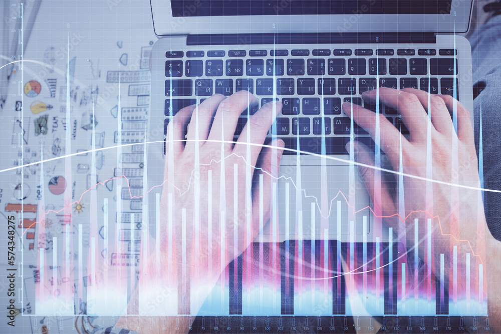 Double exposure of man's hands typing over laptop keyboard and forex chart hologram drawing. Top view. Financial markets concept. Double exposure of man's hands typing over laptop keyboard and forex chart hologram drawing. Top view. Financial markets concept.