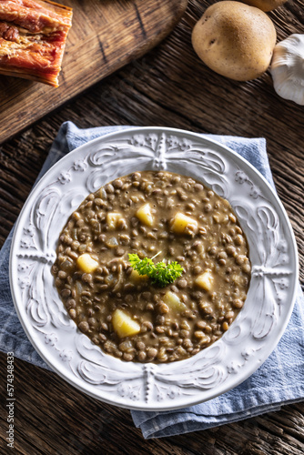 Lentil and potato soup or stew in a rustic plate decorated with parsley