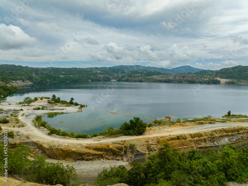 Mining quarry with flooded bottom. Lake with blue water near sand pit. Sipalay, Negros, Philippines. photo