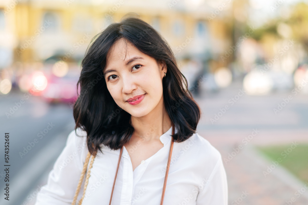 Portrait beautiful asian woman traveler smiling and looking at camera while explore street on summer vacation in Bangkok, Thailand