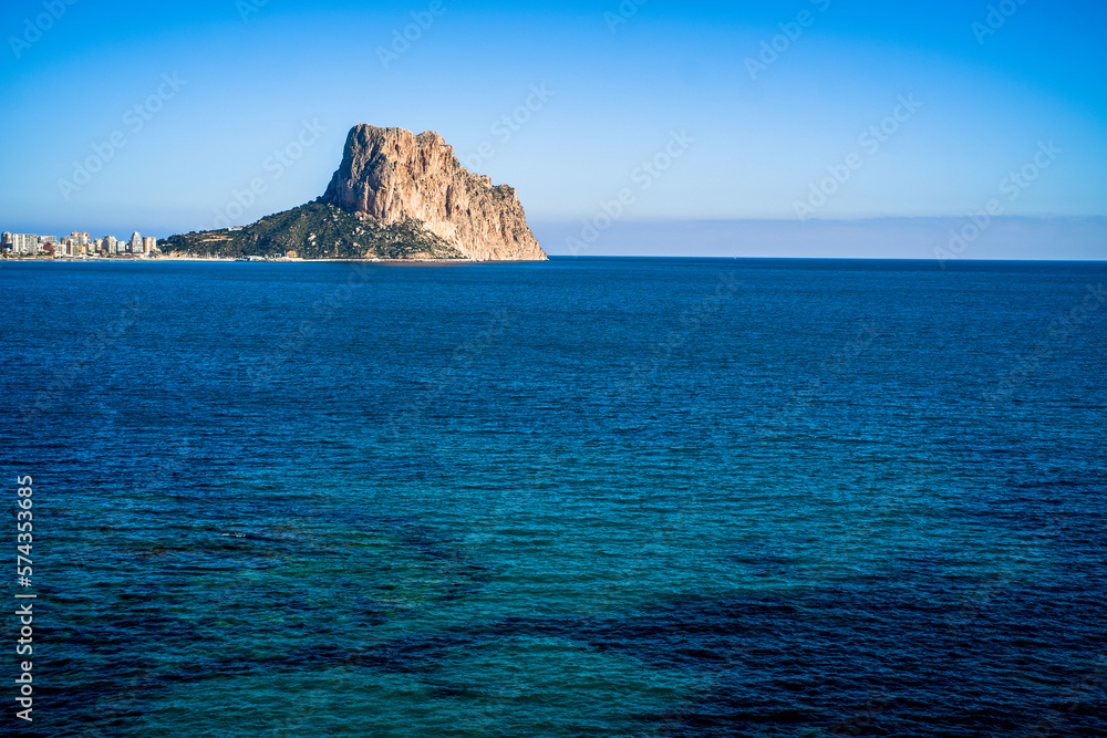 the rock of Ifach and the apartment buildings of the city of Calpe. View with the sea in the foreground