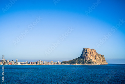 the rock of Ifach and the apartment buildings of the city of Calpe. View with the sea in the foreground photo