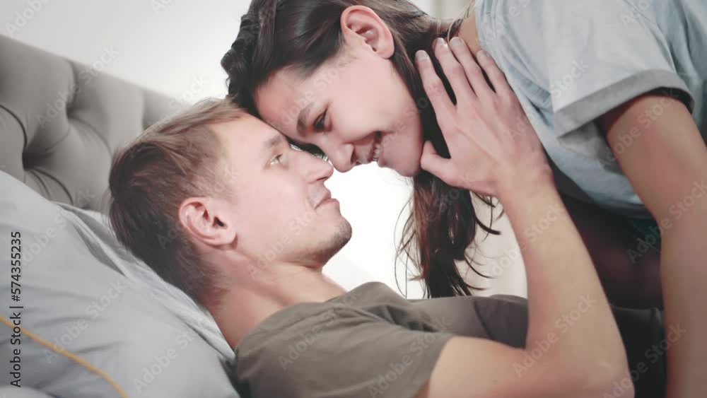 Young just married couple in love s having fun and kissing on the bed in the bedroom. Realtime Young just married couple in love s having fun and kissing on the bed in the bedroom. Realtime