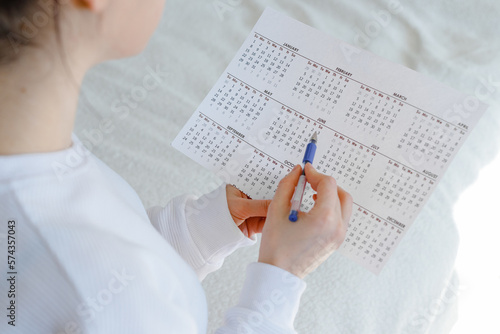 Woman planning her monthly menstruation calendar, mark the days of menstruation and ovulation. photo