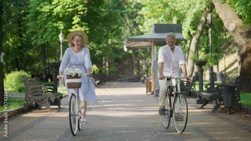 Wallpaper Mural Happy couple in their 60s riding bicycles in park, bonding relationship, love Torontodigital.ca