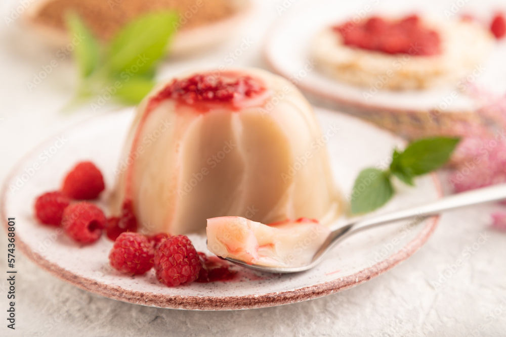 Buckwheat milk jelly with raspberry jam on gray concrete, side view, selective focus. Buckwheat milk jelly with raspberry jam on gray concrete, side view, selective focus.