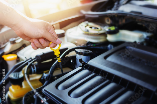 Close up of a man hand check the oil in a car motor before travel