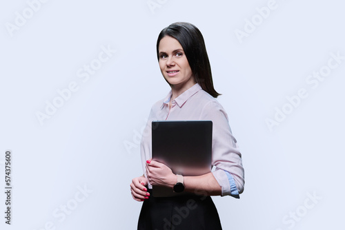 Portrait of young woman with laptop on white background