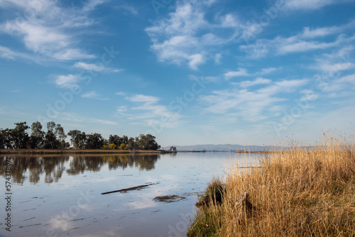 Grizzly Slough, a canal in the  Suisun Marsh near Grizzly Island road on a partly cloudy day with blue sky copy-space. This is part of the largest blackish water marsh on the West Coast USA