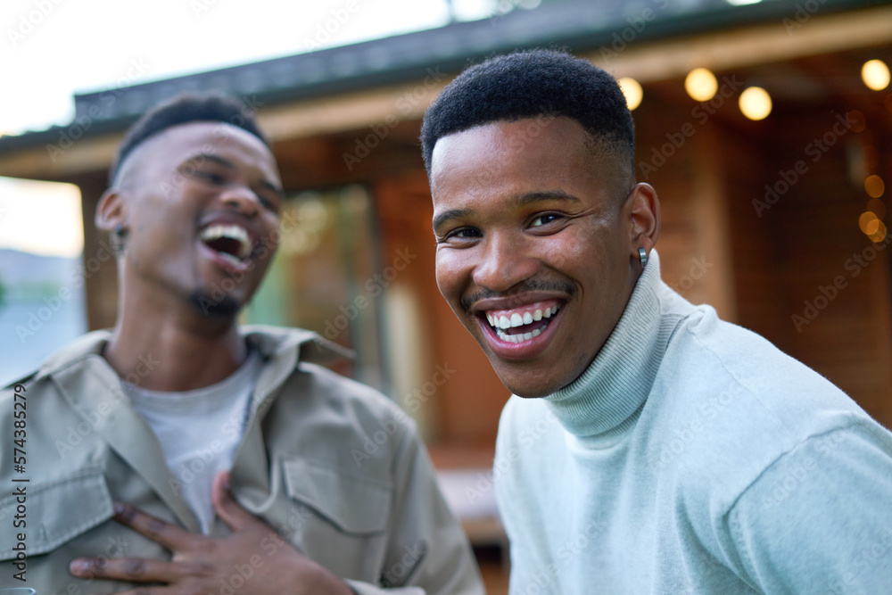 Portrait happy young gay male couple laughing on patio Portrait happy young gay male couple laughing on patio