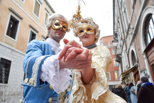 Couple dancing dressed up for Venice Carnival wearing contemporary clothes