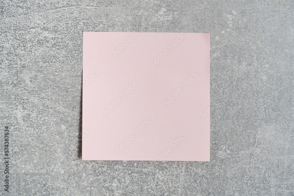 Fototapeta premium Pink paper sticker for writing notes is pasted concrete wall.