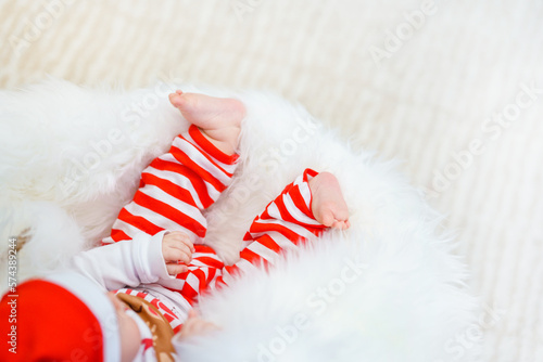 Cute tiny baby foot near the Christmas tree with lights