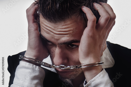 Arrested depressed man in handcuffs as a symbol of сrime and destructive antisocial behavior