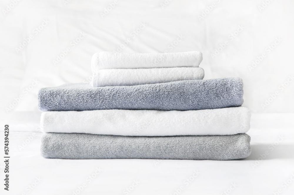 folded terry towels lie on clean white bed. Cleaning in guest room of hotel, cleanliness, laundry folded terry towels lie on clean white bed. Cleaning in guest room of hotel, cleanliness, laundry