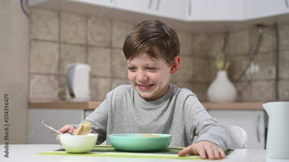 Boy enjoys a delicious meal of traditional Ukrainian dumplings at dinner table. His eyes light up with pleasure as he savors each bite, savoring the rich and comforting flavors of home-cooked food. Boy enjoys a delicious meal of traditional Ukrainian dumplings at dinner table. His eyes light up with pleasure as he savors each bite, savoring the rich and comforting flavors of home-cooked food.