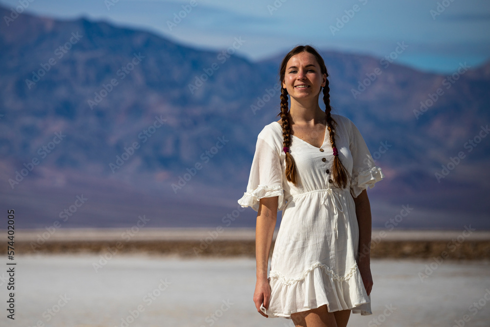 beautiful native american girl walking on the salt flats in badwater basin, death valley national park, california, usa; girl with pigtails in lace dress beautiful native american girl walking on the salt flats in badwater basin, death valley national park, california, usa; girl with pigtails in lace dress