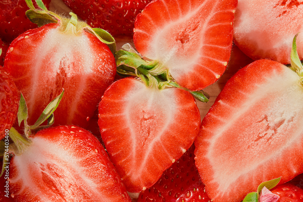 Ripe strawberry halves on wooden table, berry seasonal harvest, top view, idea for strawberry background or dessert and smoothie preparation Ripe strawberry halves on wooden table, berry seasonal harvest, top view, idea for strawberry background or dessert and smoothie preparation