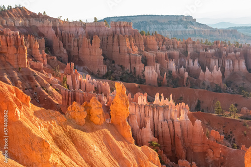 Panoramic morning sunrise view on sandstone rock formation seen from Thor hammer on Navajo Rim trail, Bryce Canyon National Park, Utah, USA. Golden hour colored hoodoos in unique natural amphitheatre