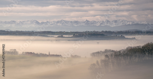 Sunrise in the mist in the Gers department in France with the Pyrenees in the background