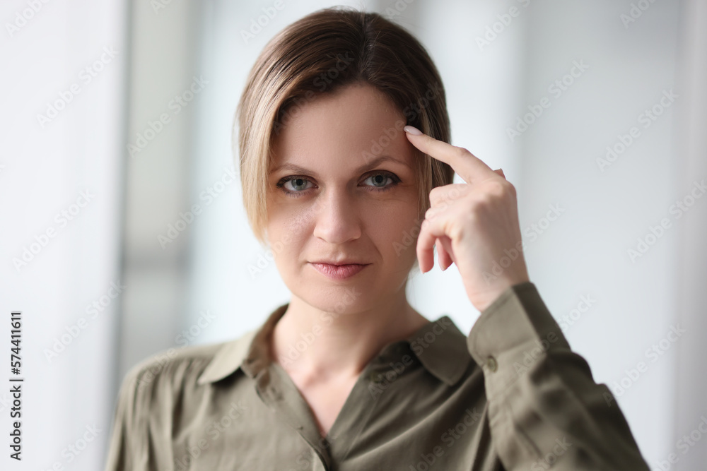 Portrait of a thinking woman with a finger on the forehead Portrait of a thinking woman with a finger on the forehead