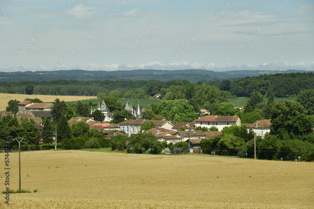 Le bourg de Champagne niché dans un cadre champêtre en contrebas d'un champ de blé au Périgord Vert 