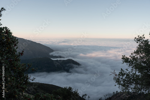 A landscape view above the clouds from the top of a mountain during the sunset