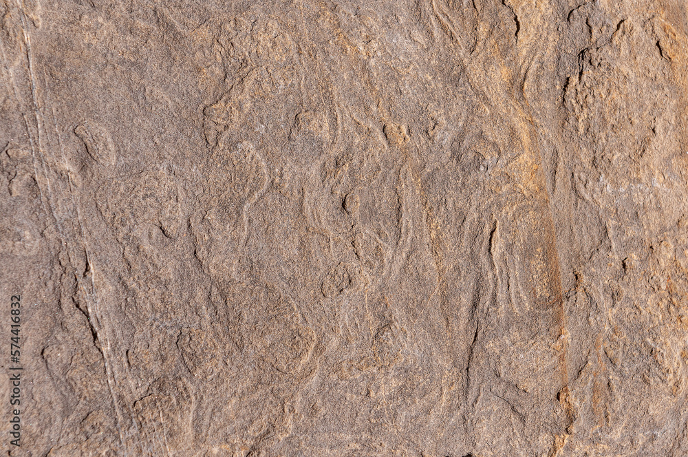 Naklejka premium Stone textured wall is sand colored with orange patterns and various bulges. Stone background is sand-colored.