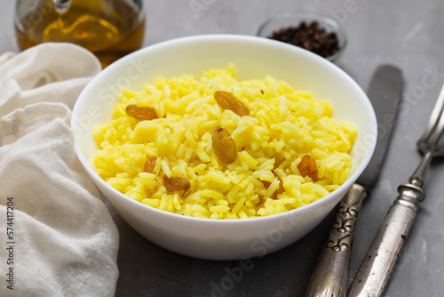 Yellow rice with dried fruit in white bowl