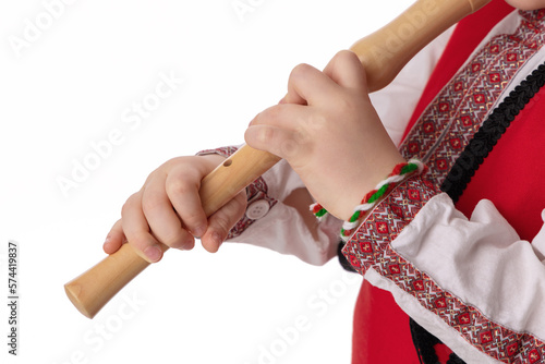 Bulgarian boy musician with flute in traditional folklore costume with martenitsa symbol of spring, Baba Marta and Easter holiday, portrait on white background photo