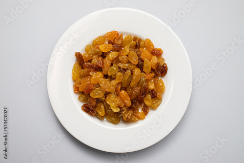 Yellow golden raisins in white ceramic plate