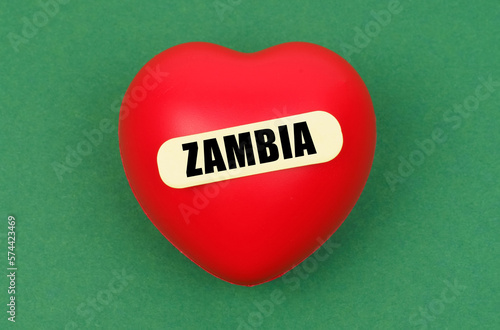 On a green surface lies a red heart with the inscription - Zambia