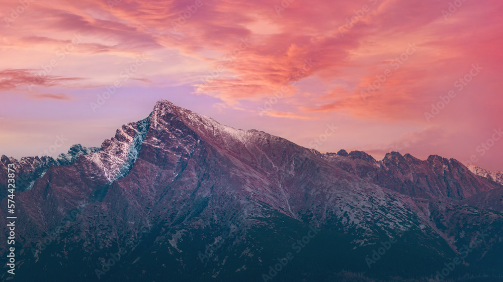 Pink purple afternoon clouds sky over mount Krivan peak - Slovak symbol - forest trees silhouettes in foreground, evening scene Pink purple afternoon clouds sky over mount Krivan peak - Slovak symbol - forest trees silhouettes in foreground, evening scene
