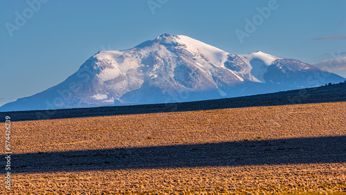 The snow covered strato volcano Guallatiri on the high altitude plateau of the Andes (Altiplano) in the north of Chile photo