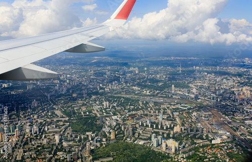 Passenger plane over Kyiv, Ukraine. Aerial top view of hisotrical city center. Airplane wing.