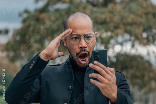 surprised and amazed businessman looking at mobile phone photo