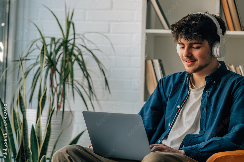 Obraz premium young man at home with laptop and headphones