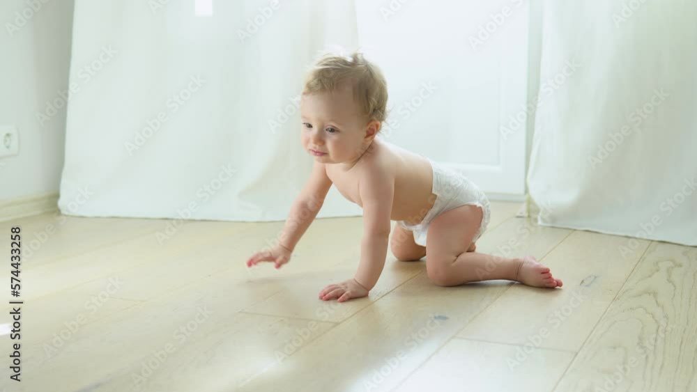 Smiling crawling cute baby in diaper at home on floor Smiling crawling cute baby in diaper at home on floor
