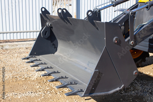 Construction road special transport - front loader. Metal dipper with teeth close-up. 
