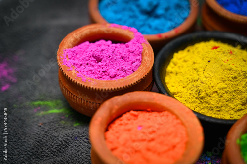 top view of colorful traditional holi powder in bowls isolated on dark background.Space for text . happy holi.Concept Indian color festival called Holi © shouvik