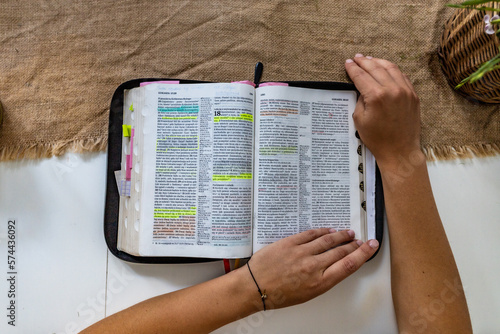 Reading Holy Bible with colorful highlights on pages which is lie on wooden table photo
