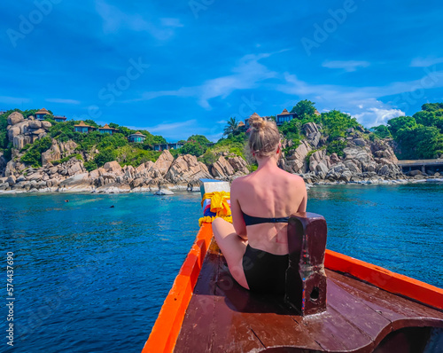 First person view of a traditional long tail boat with a girl sitting in front in Andaman sea in Thailand, Koh Tao island