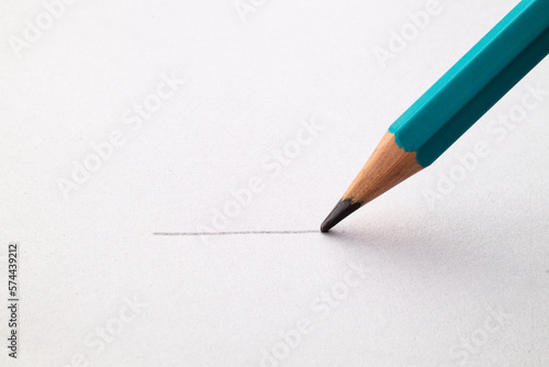 Draws a line on paper with a pencil. Close up. Macro